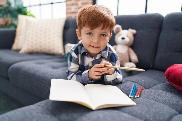 Liebenswertes Kleinkind Zeichnet Auf Notizbuch Das Hause Auf Dem Sofa — Stockfoto