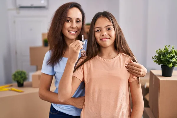 stock image Woman and girl mother and daughter holding key at new home