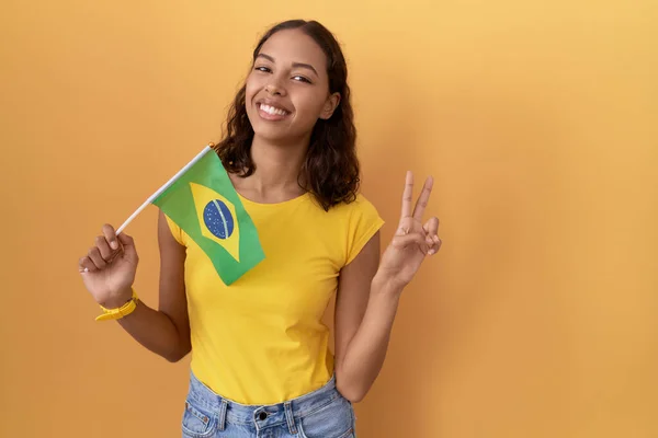 Молодая Латиноамериканка Бразильским Флагом Улыбается Глядя Камеру Показывая Пальцы Делающие — стоковое фото