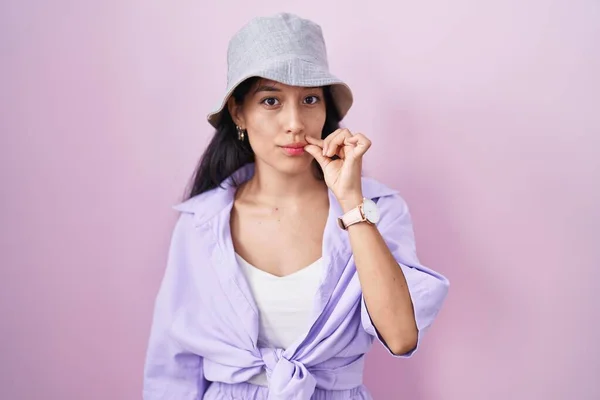 Молодая Латиноамериканка Стоящая Розовом Фоне Шляпе Закрытыми Губами Молния Пальцами — стоковое фото