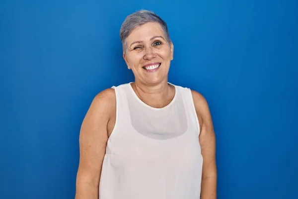 Middle Age Caucasian Woman Standing Blue Background Winking Looking Camera — Stock Photo, Image