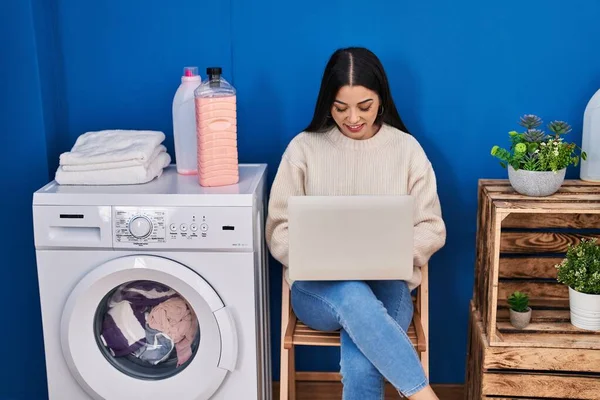 Young Beautiful Hispanic Woman Using Laptop Waiting Washing Machine Laundry — 图库照片