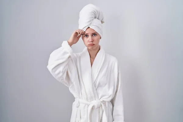 バスローブを着たブロンドの白人女性は額に手で問題について心配し 強調し 危機への不安と不安 — ストック写真