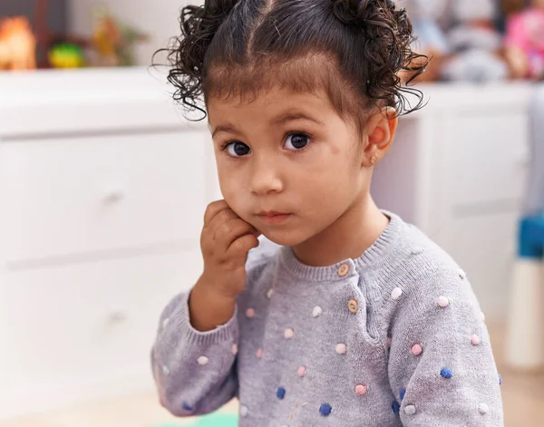 stock image Adorable hispanic girl sitting on floor with sad expression at kindergarten