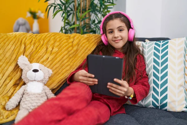 Adorável Menina Hispânica Usando Touchpad Fones Ouvido Sentado Sofá Casa — Fotografia de Stock