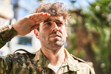 Young man army soldier doing militar salute at park