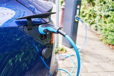 Elektrikli araba sokakta şarj oluyor.