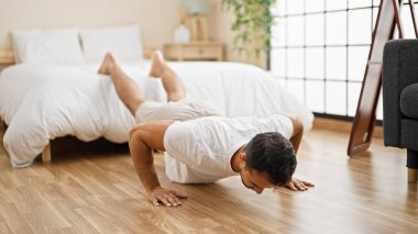 Genç İspanyol adam antrenman yapıyor. Yatak odasında şınav çek.