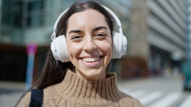 Genç, güzel, İspanyol bir kadın. Kendine güvenen, sokakta müzik dinleyen.