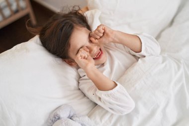 Sevimli İspanyol kız yatakta uzanıyor ve yatak odasında uyanıyor.