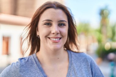 Young beautiful plus size woman smiling confident standing at street