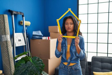 Genç Asyalı kadın yeni bir eve taşınıyor şüpheci ve gergin, sorun yüzünden somurtuyor. negatif kişi. 