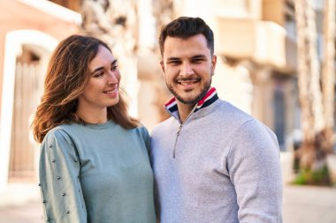 Man and woman smiling confident hugging each other standing at street