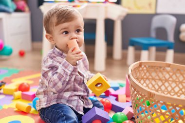 Beyaz çocuk anaokulunda inşaat bloğu emiyor.