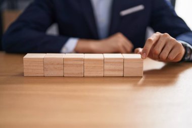 Ofiste tahta küplerle masada oturan genç sarışın bir iş adamı.