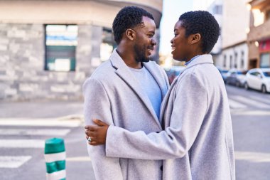 Man and woman couple hugging each other standing at street
