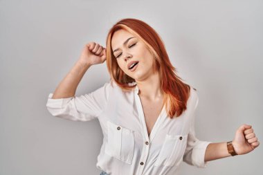 Kafkas 'lı genç bir kadın izole edilmiş arka planda duruyor. Yorgun ve rahat, uykulu ve sabahın erken saatlerinde esniyor. 