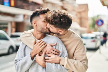 Young couple hugging each other kissing at street