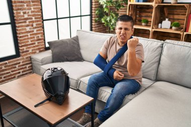 Motosiklet kazası için kol askısı takan İspanyol genç adam öfkeyle bağırıyor, öfkeyle bağırıyor ve el kaldırıyordu. 