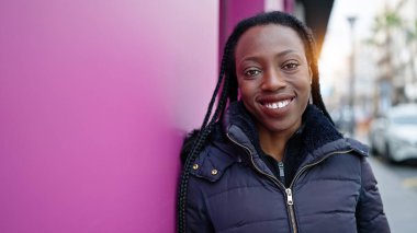Sokakta kendine güvenen Afrikalı Amerikalı kadın gülümsüyor