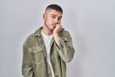 Tecrit edilmiş arka planda duran genç İspanyol adam çapraz kollarla depresyon sorunlarından sıkılmış ve yorgun göründüğünü düşünüyor.. 