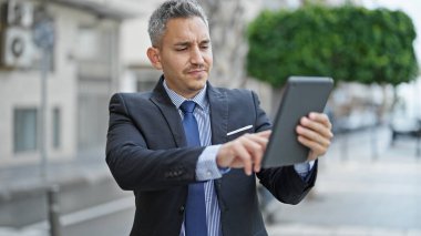 Sokakta dokunmatik ped kullanan İspanyol bir iş adamı.