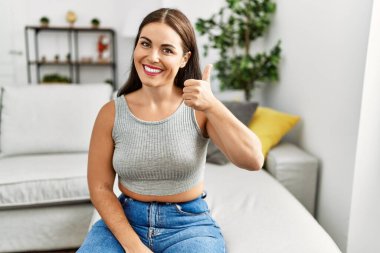 Genç ve güzel İspanyol kadın evdeki kanepede oturan sağırlarla iletişim kuruyor.