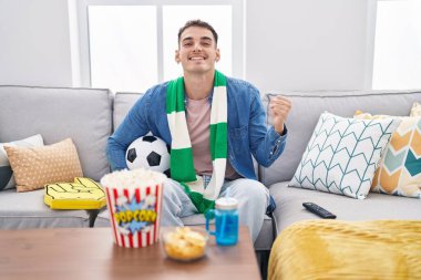 Yakışıklı İspanyol adam topu tutuyor. Gururla bağırıyor, zaferi kutluyor ve kollarını kaldırarak başarıyı kutluyor. 