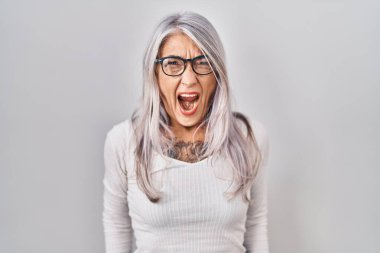Beyaz arka planda gri saçlı, öfkeli ve öfkeli bir şekilde bağıran öfkeli ve sinirli bir orta yaşlı kadın. öfke ve agresif konsept. 