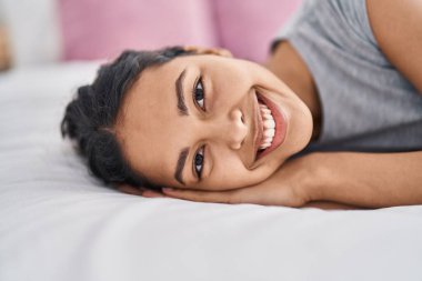 Young african american woman smiling confident lying on bed at bedroom