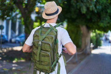 Young caucasian man tourist walking on back view at street