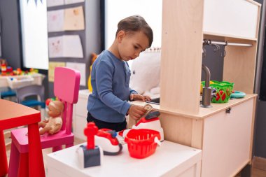 Anaokulunda süper market oyunu oynayan sevimli İspanyol çocuk.