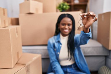 African american woman smiling confident holding key at new home
