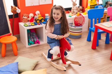 Sevimli İspanyol kız anaokulunda ren geyiğiyle oynuyor.