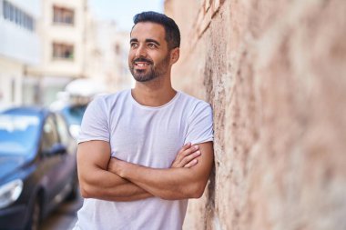 Genç İspanyol adam gülümsüyor. Kendine güveni tam. Sokakta çapraz hareketlerle duruyor.