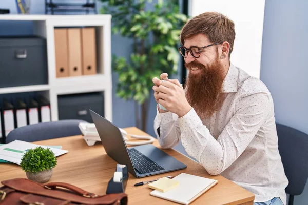 若い赤毛のサラリーマンオフィスでノートパソコンのコーヒーを使用して — ストック写真
