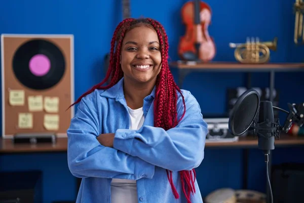 African american woman artist smiling confident standing with arms crossed gesture at music studio