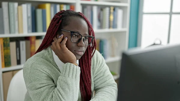 大学図書館でコンピュータを使用して編組髪の学生を持つアフリカの女性 — ストック写真