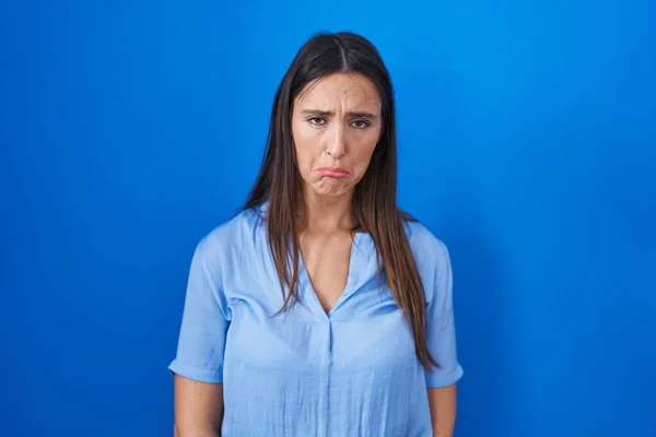 Jonge Brunette Vrouw Staat Blauwe Achtergrond Depressief Zorgen Maken Voor — Stockfoto