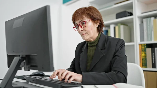 Mature hispanic woman university teacher using computer at library university