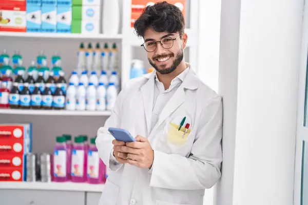 Joven Farmacéutico Hispano Usando Smartphone Trabajando Farmacia —  Fotos de Stock