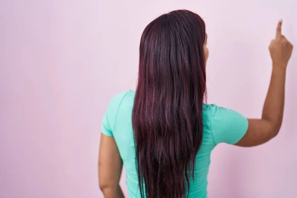 Young Hispanic Woman Standing Pink Background Posing Backwards Pointing Ahead — 스톡 사진