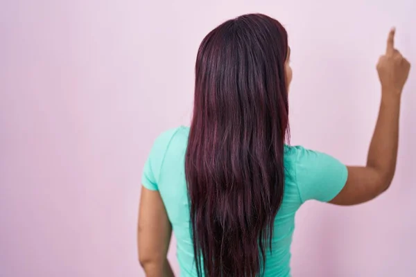 Young Hispanic Woman Standing Pink Background Posing Backwards Pointing Ahead — Stock fotografie