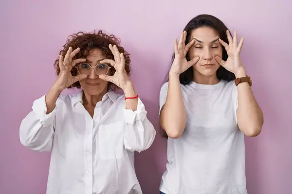 Hispanic Mother Daughter Wearing Casual White Shirt Pink Background Trying — 图库照片