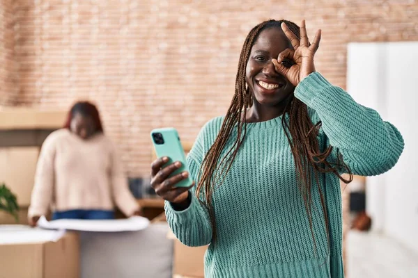 Yeni Evinde Akıllı Telefon Kullanan Afrikalı Bir Kadın Gülümsüyor Mutluluktan — Stok fotoğraf