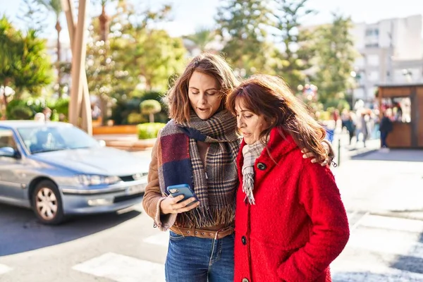 Två Kvinnor Mor Och Dotter Använder Smartphone Med Avslappnad Uttryck — Stockfoto