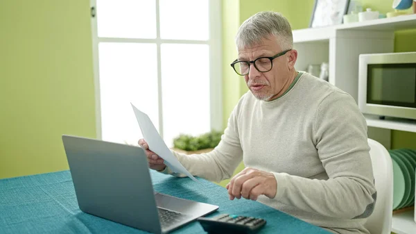 Evde Dizüstü Bilgisayar Okuyan Orta Yaşlı Kır Saçlı Bir Adam — Stok fotoğraf