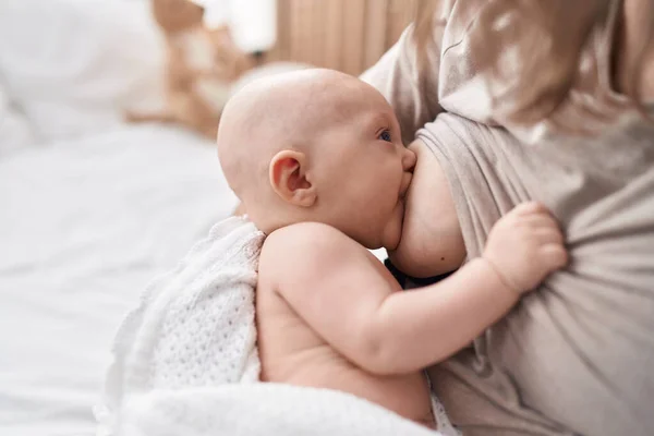 스러운 아기가 침대에 어머니가 아기를 빨아먹고 침실에서 식사를 — 스톡 사진