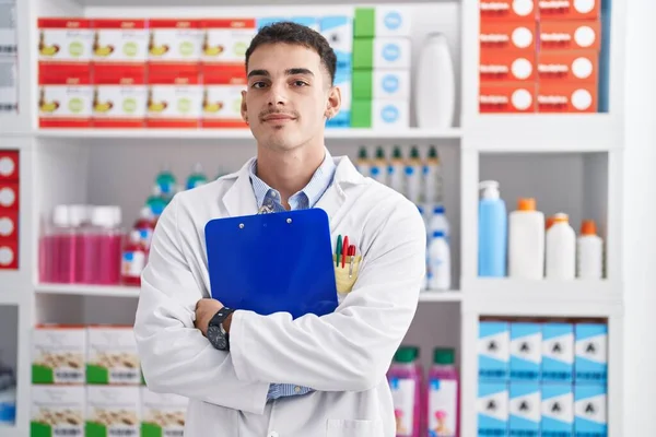 Young Hispanic Man Pharmacist Holding Clipboard Pharmacy — Fotografia de Stock