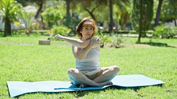 Middelbare Leeftijd Vrouw Stretching Armen Zittend Yoga Mat Park — Stockfoto
